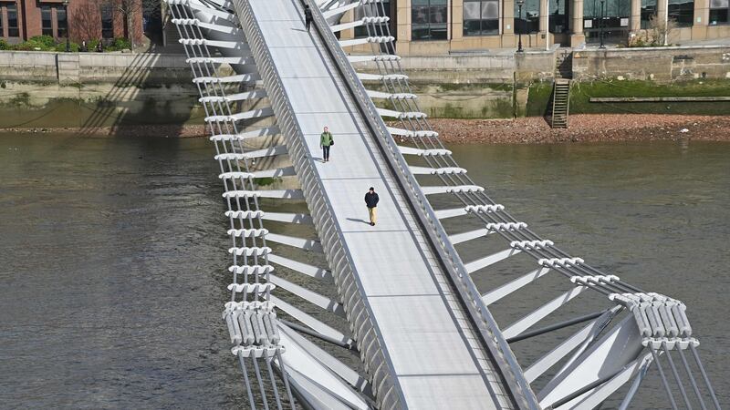Pedestrians cross a quiet Millennium Footbridge across the River Thames in London in the mid-morning on March 17th, after the UK government announced stricter measures and social distancing advice to deal with the novel coronavirus outbreak. Photograph: Justin Tallis/AFP/Getty Images