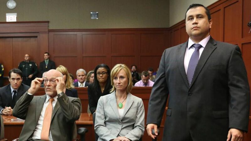 George Zimmerman stands when the jury arrives to deliver the verdict in his murder trial as his attorneys Don West and Lorna Truett await the announcement. Photograph: Joe Burbank/Reuters.
