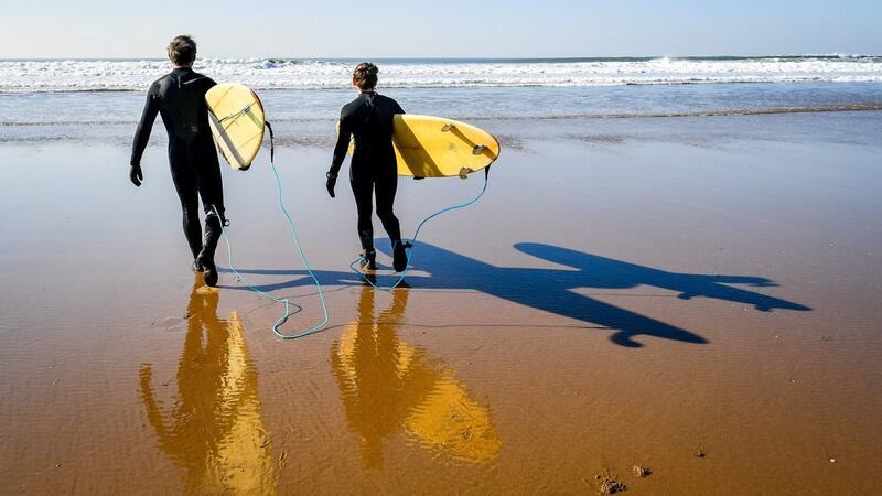 Surfers create shadows in strong sunshine as they prepare to enter the sea at Woolacombe, North Devon. Photograph: Ben Birchall/PA Wire
