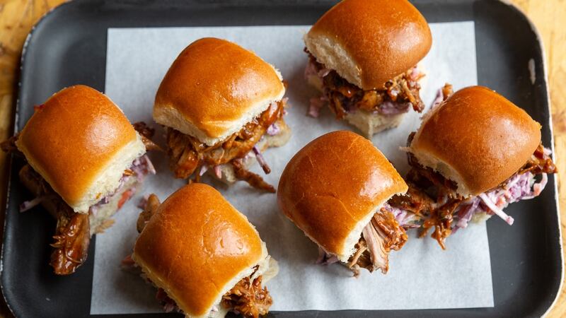 Pulled pork sliders come with a variety of sauces.