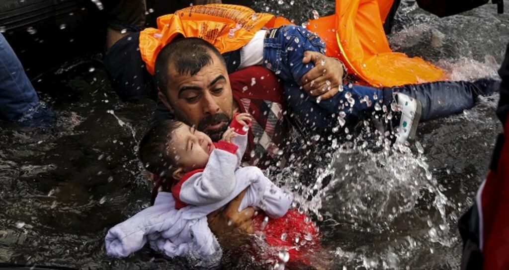 Photograph of the day: A Syrian refugee holds onto his children as he struggles to walk off a dinghy on the Greek island of Lesbos, after crossing a part of the Aegean Sea from Turkey to Lesbos September 24, 2015. Reuters and The New York Times shared the Pulitzer Prize for breaking news photography for images of the migrant crisis in Europe and the Middle East. Photograph: Yannis Behrakis/Reuters
