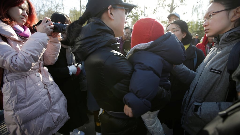 A parent is surrounded by members of the media outside the kindergarten run by pre-school operator RYB Education  in Beijing, China. Photograph: Jason Lee/Reuters