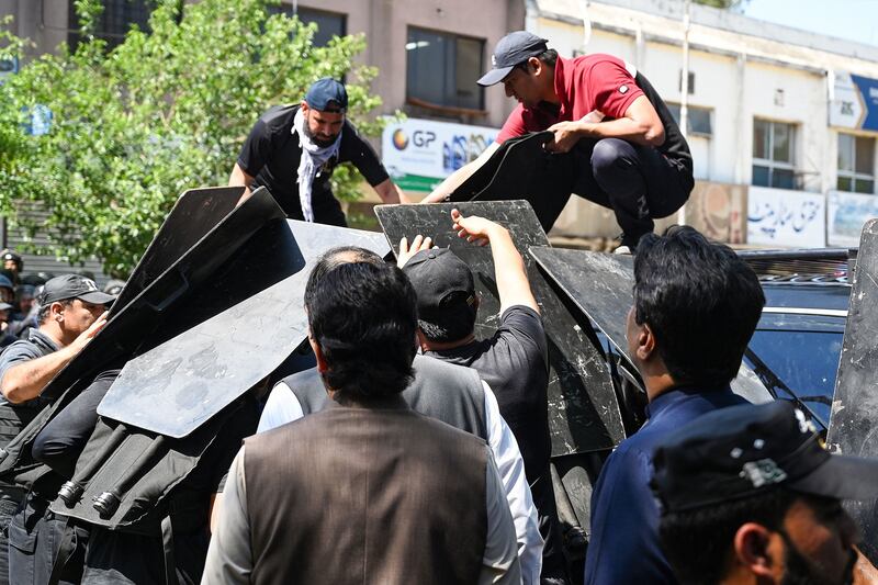 Security personnel use bullet proof shields to protect Pakistan's former prime minister Imran Khan as he arrives at the high court in Islamabad. Photograph: Aamir Qureshi/ AFP