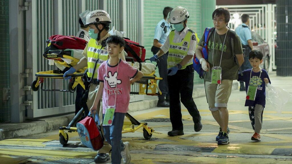 Ferry passengers walk with rescuers after arriving in  Hong Kong on Sunday.  About 100 people were injured when a ferry returning from Macau to Hong Kong collided with an unknown object, a police department official said. Photograph: Reuters