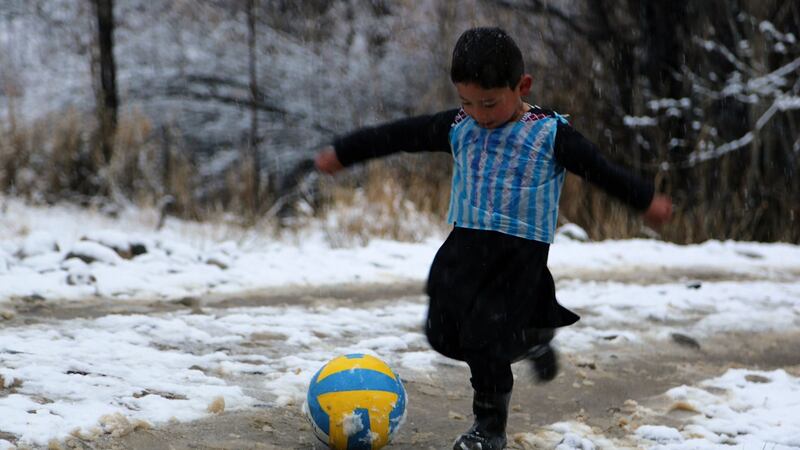 In this photograph taken in January 2016, Afghan boy and Lionel Messi fan Murtaza Ahmadi (5) wears a plastic bag jersey as he plays football in Jaghori district of Ghazni province. Photograph: Getty