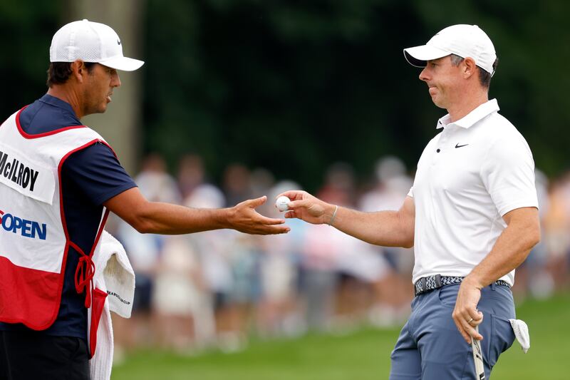 Rory McIlroy hands his ball to his caddie Harry Diamond during the final round of the US Open. Photograph: Cliff Hawkins/Getty Images