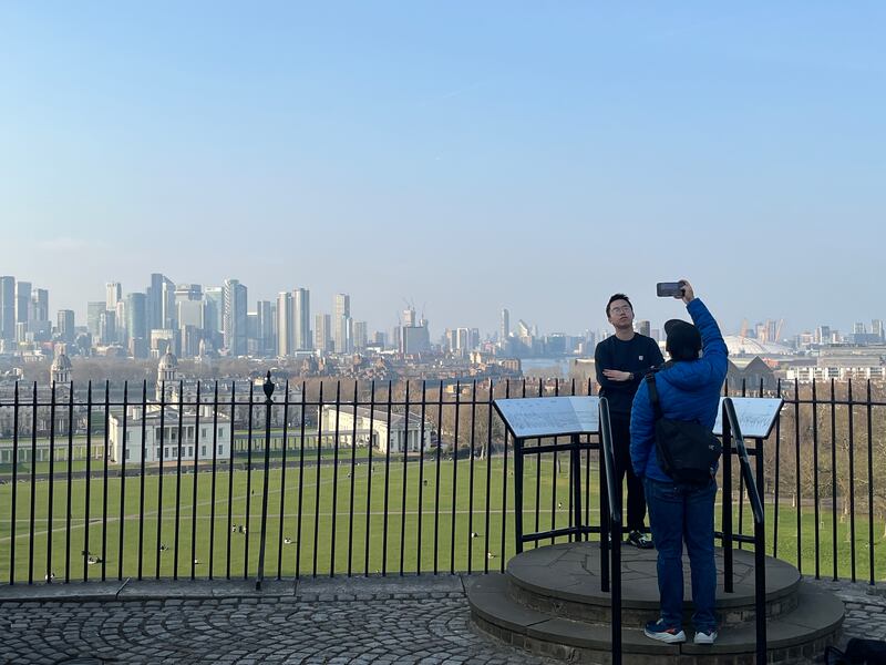 Tourists looking out over Canary Wharf from high on a hill in Greenwich Park, at the Royal Observatory. Photograph: Mark Paul