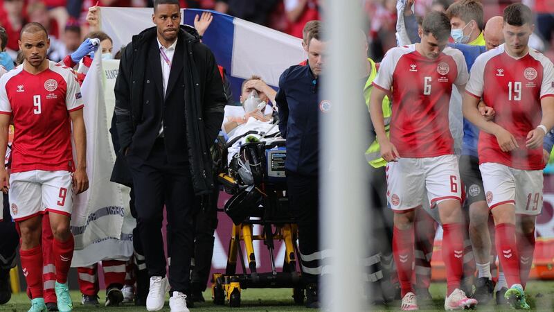 Denmark’s players escort Christian Eriksen as he is taken from the pitch on a stretcher after collapsing during the opening game against Finland at the Parken Stadium in Copenhagen. Photograph: Friedemann Vogel/AFP via Getty Images