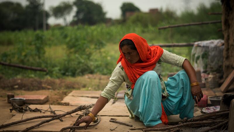 The neighbour: Anjum breaks wood for a cooking fire in Peepli Kera, India.  She tried to intervene when Mukesh was beating his wife to death, but others just watched. Photograph: Andrea Bruce/New York Times