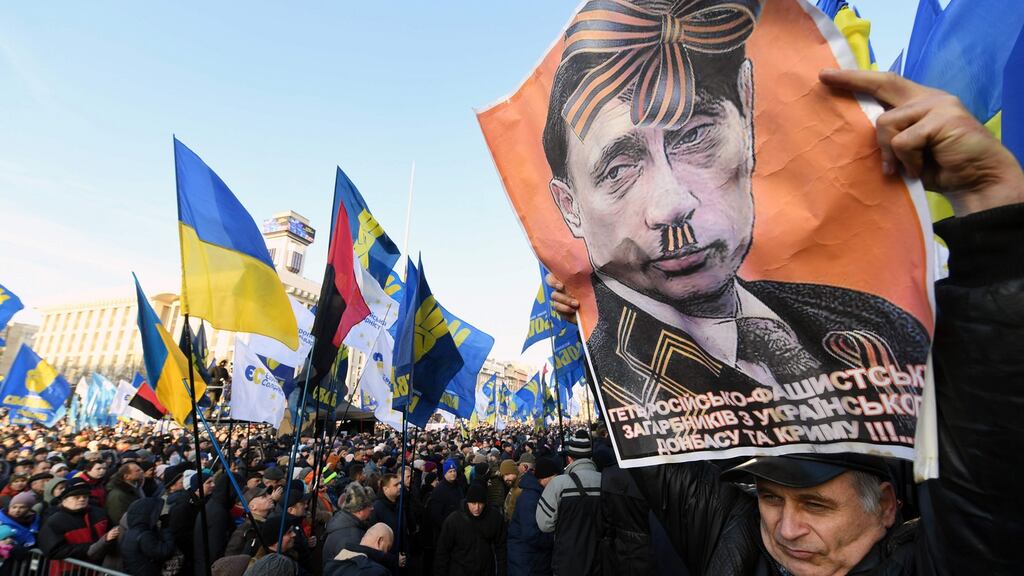 An activist holds a poster depicting Russian president Vladimir Putin as people gather for a mass rally to demand “no capitulation” to Russia, at the Independence Square in Kiev. Photograph: Sergei Supinsky/AFP