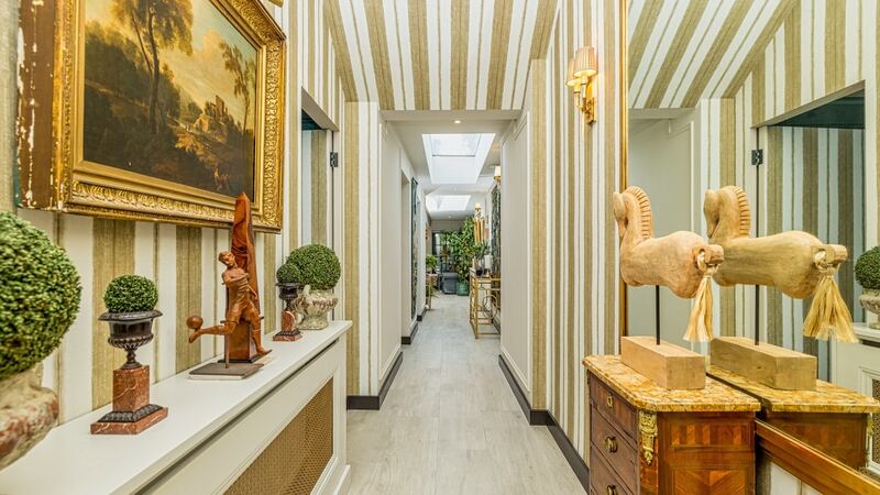 The house opens from the street into a dramatically dark hall, painted a deep aubergine