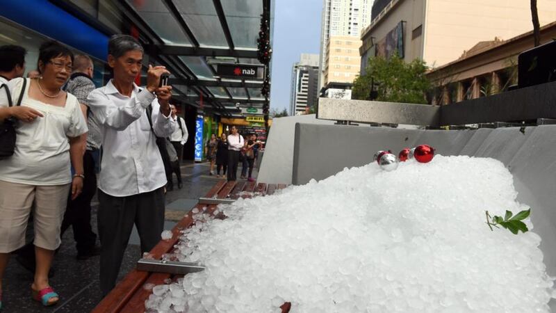 People take photos of a pile of hail stones in Brisbane’s central business district after a severe thunderstorm swept through the city. Photograph: Dan Peled/EPA.