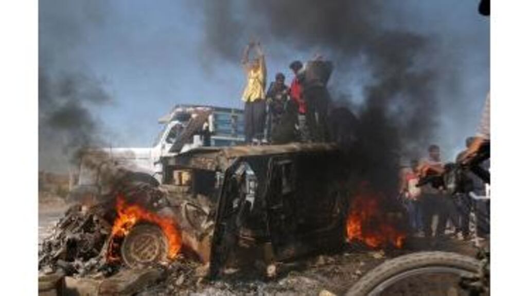 Iraqis celebrate on a US army Humvee after it was attacked in Baghdad yesterday