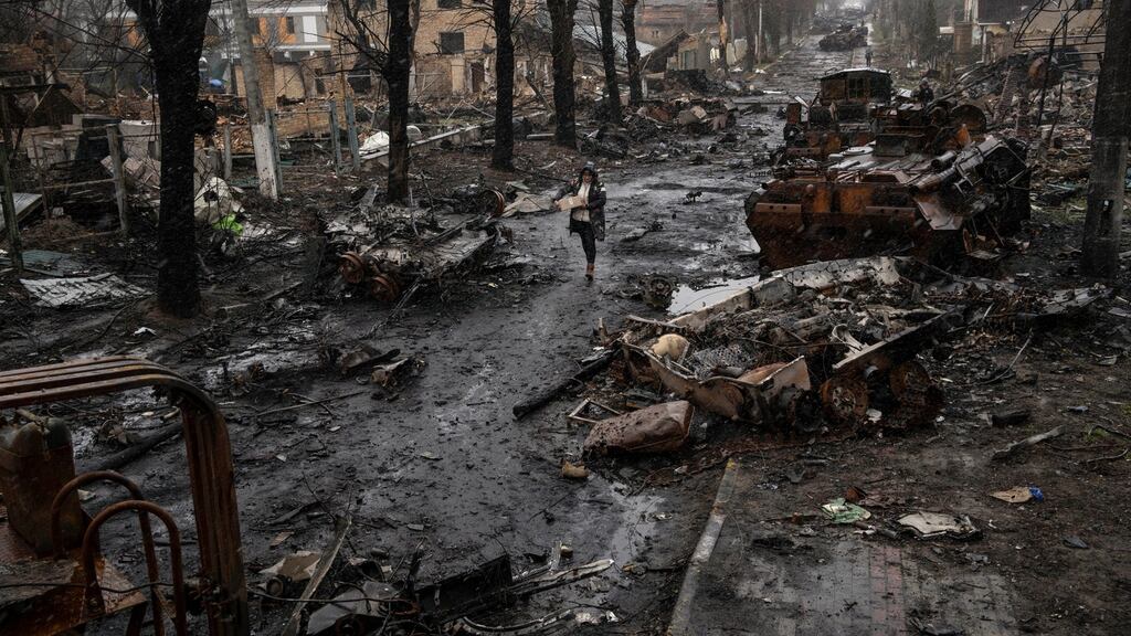 A woman walks amid destroyed Russian tanks in Bucha, in the outskirts of Kyiv, Ukraine. Photograph: Rodrigo Abd/AP Photo