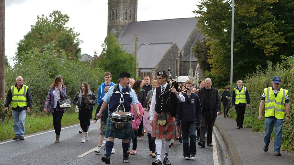 A procession walks from the grave side of Seamus Heaney in Bellaghy through the village to the Turfman on the first Anniversary of the poet’s death. Photograph: Alan Betson