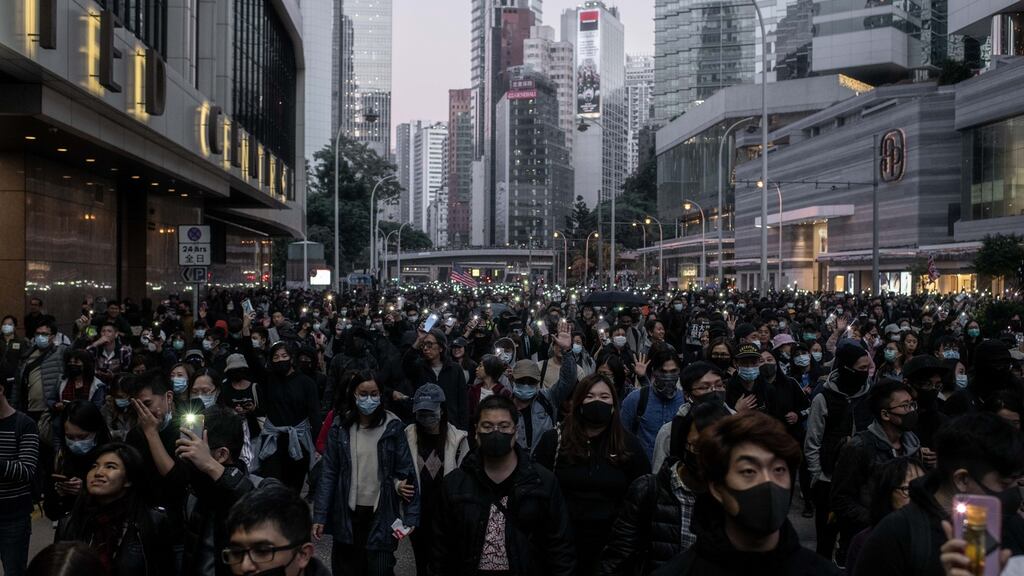 Demonstrators shine lights from their smartphones and march during a protest in the Admiralty district of Hong Kong, China. Photographer: Ivan Abreu/Bloomberg