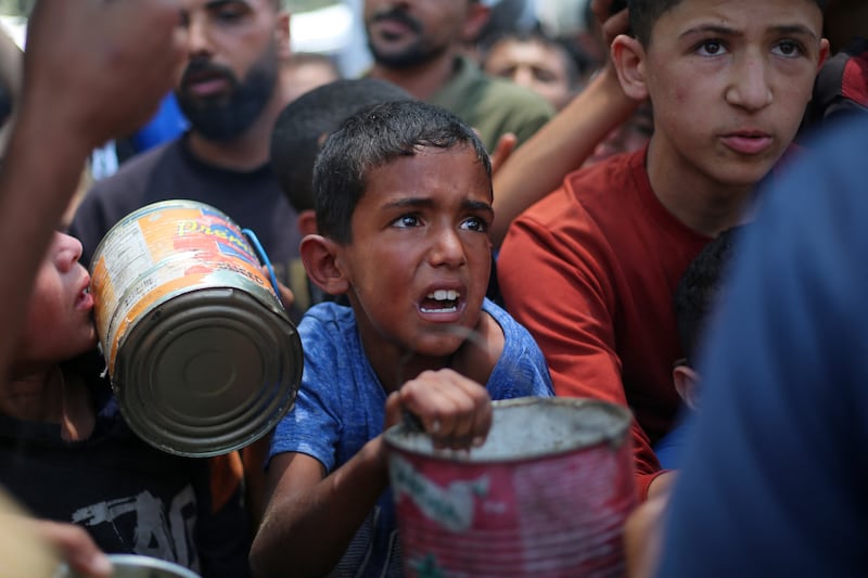 Palestinian children wait for food at a distribution point in Nuseirat, in the central Gaza Strip. Photograph: Eyad Baba/AFP via Getty Images)
