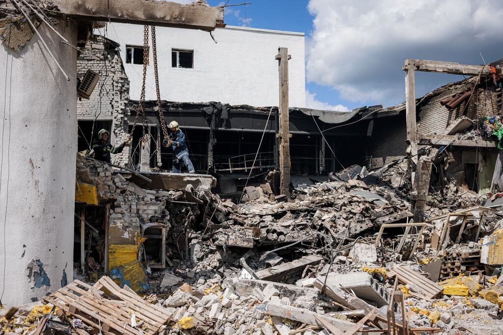 Firefighters clear rubble at a destroyed cultural centre hit by an airstrike in Derhachi, near Kharkiv. File photograph: Dimitar Dilkoff/AFP via Getty Images