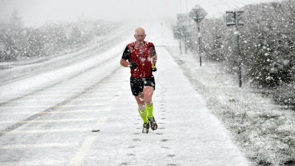 A runner battles through a heavy snow shower in Tuam, Co Galway. Photograph: Ray Ryan