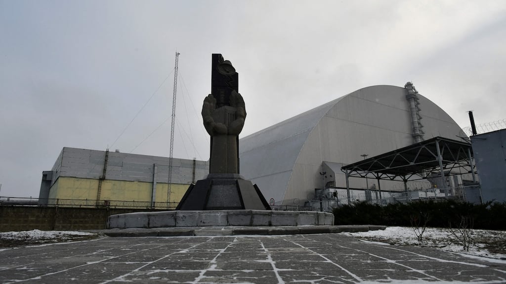 A monument in front of the giant protective dome built over the sarcophagus of the destroyed fourth reactor of Chernobyl nuclear power plant. Photograph: Genya Savilov/AFP via Getty