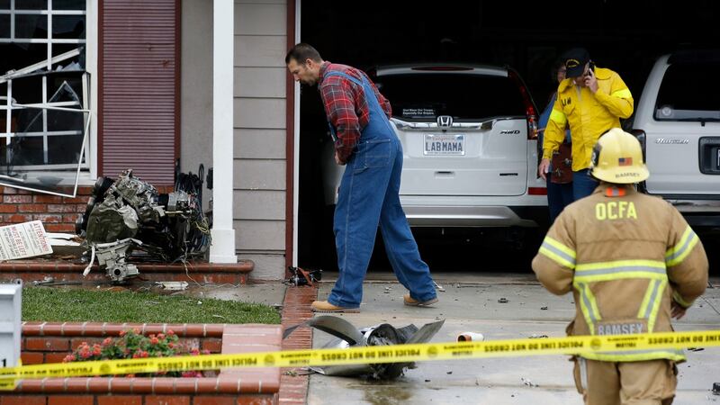 A resident looks at debris that hit a house after a small plane crashed into the neighbourhood of Yorba Linda, California.  Photograph: Alex Gallardo/AP