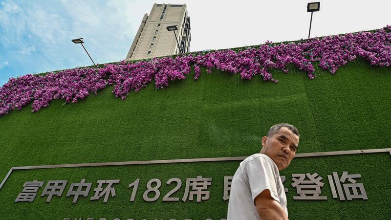 A man walks past a residential building developed by Evergrande in Shanghai this week. Photograph: Hector Retamal/AFP via Getty
