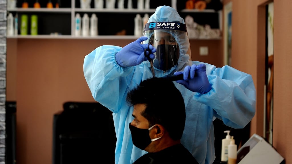 A hairdresser wears protective equipment during haircut in Bangalore, India. Photograph: Jagadeesh NV/EPA