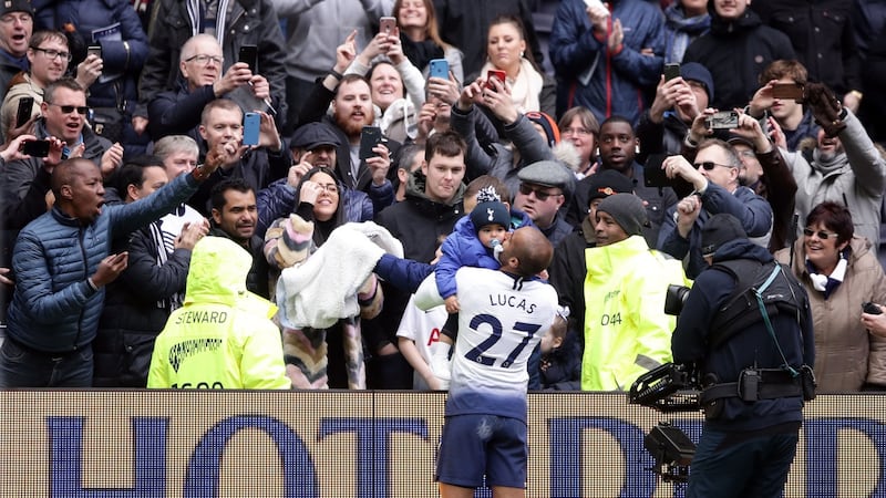 Lucas Moura celebrates with his son after Tottenham’s win over Huddersfield. Photograph: John Walton/PA