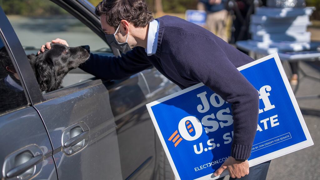 Democratic Georgia US Senate candidate Jon Ossoff greets a dog while participating in a drive-through campaign event in Alpharetta, Georgia. Photograph: EPA/Erik S Lesser