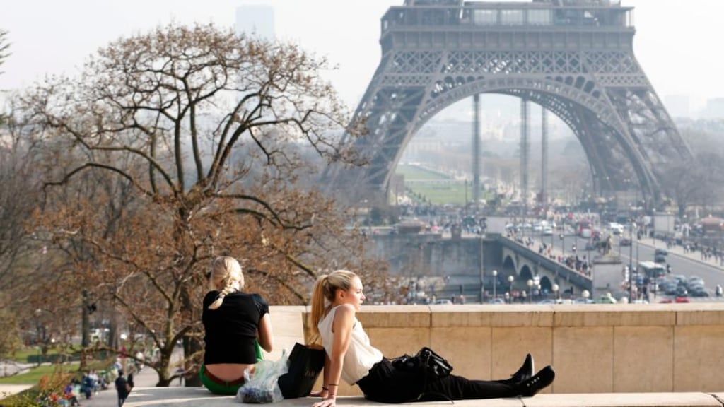 Tourists enjoy the sunny weather in front of the Eiffel tower in Paris. Swathes of France, including the French capital, are on maximum alert over air pollution. Photograph: Charles Platiau/Reuters