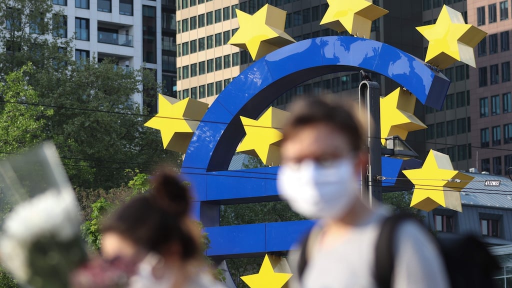 People wearing face masks walk in front of the European Central Bank in Frankfurt. Photograph: Yann Schreiber/AFP