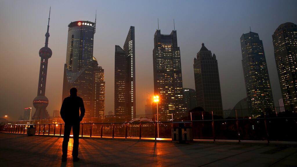 A man looks at the Pudong financial district of Shanghai: China’s economy has registered its slowest growth in a quarter century. Photograph: REUTERS/Carlos Barria/Files