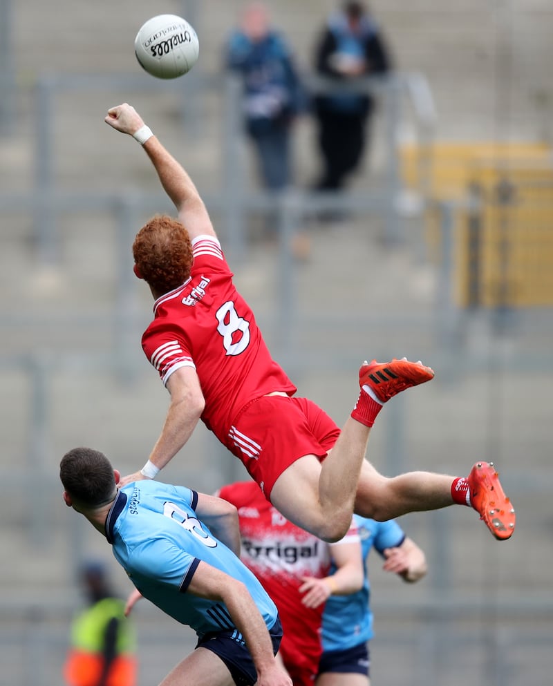 Derry's Conor Glass climbs above Brian Fenton of Dublin to reach the ball. Photograph: Leah Scholes/Inpho