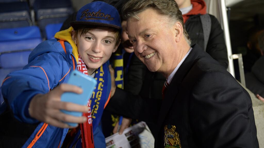 Manchester United manager Louis van Gaal poses for a fixture with a young fan after his side’s FA Cup fifth round win over Shrewsbury Town. Photo: Oli Scarff/Getty Images