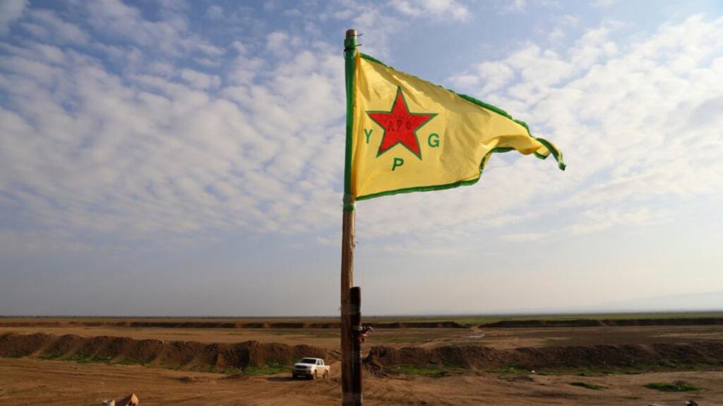 A Kurdish People’s Protection Units (YPG) flag flutters on a lookout point between the Iraqi-Syrian border town of Rabia and the town of Snuny, north of Mount Sinjar. Photograph: Massoud Mohammed/Reuters.