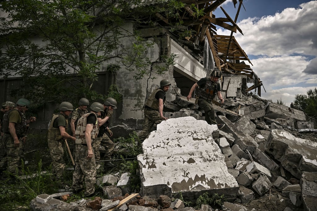 Ukrainian soldiers inspect a destroyed warehouse in the eastern Ukrainian region of Donbas. Photograph: ARIS MESSINIS/AFP via Getty Images