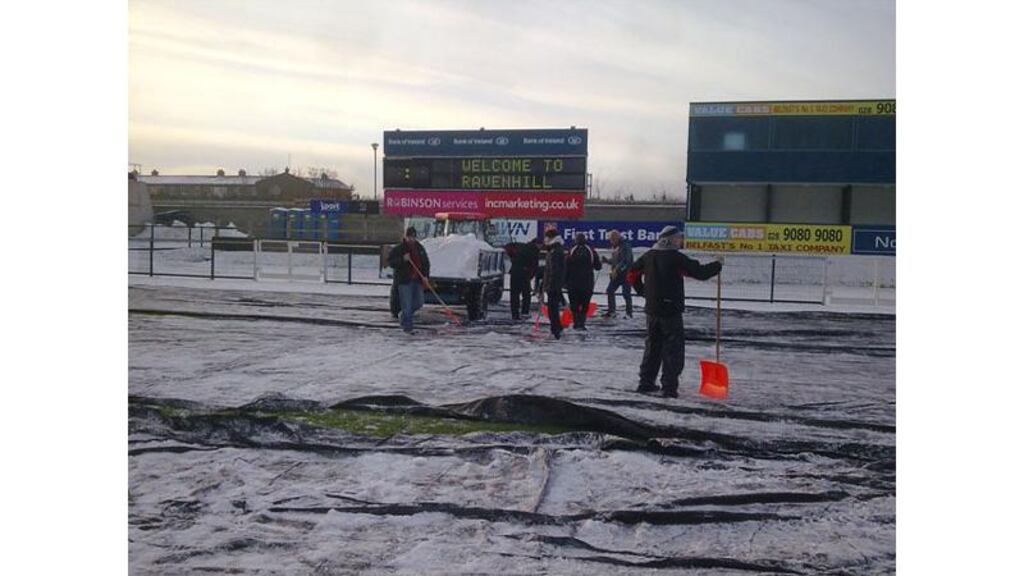 Staff and volunteers clear the snow from the Ravenhill pitch last Saturday. They were out again this morning following another heavy fall last night. Photograph: ulsterrugby.com