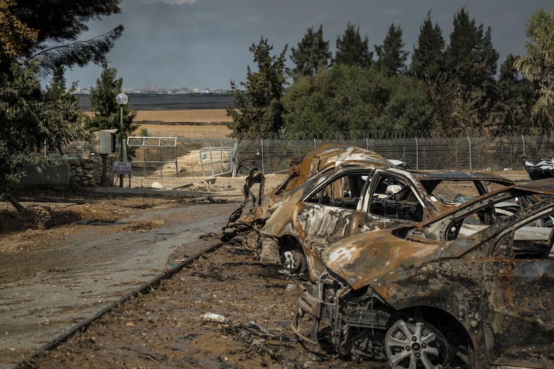 Smoke billowing from Gaza City is seen through the security fence in Kfar Azza, a village just across the border from Gaza that was attacked by Palestinian gunmen, in Israel. Photograph: Sergey Ponomarev/New York Times