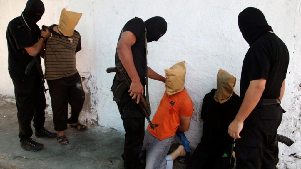 Hamas militants grab Palestinians suspected of collaborating with Israel, before executing them in Gaza City on Friday. Photogtaph: Reuters/Stringer