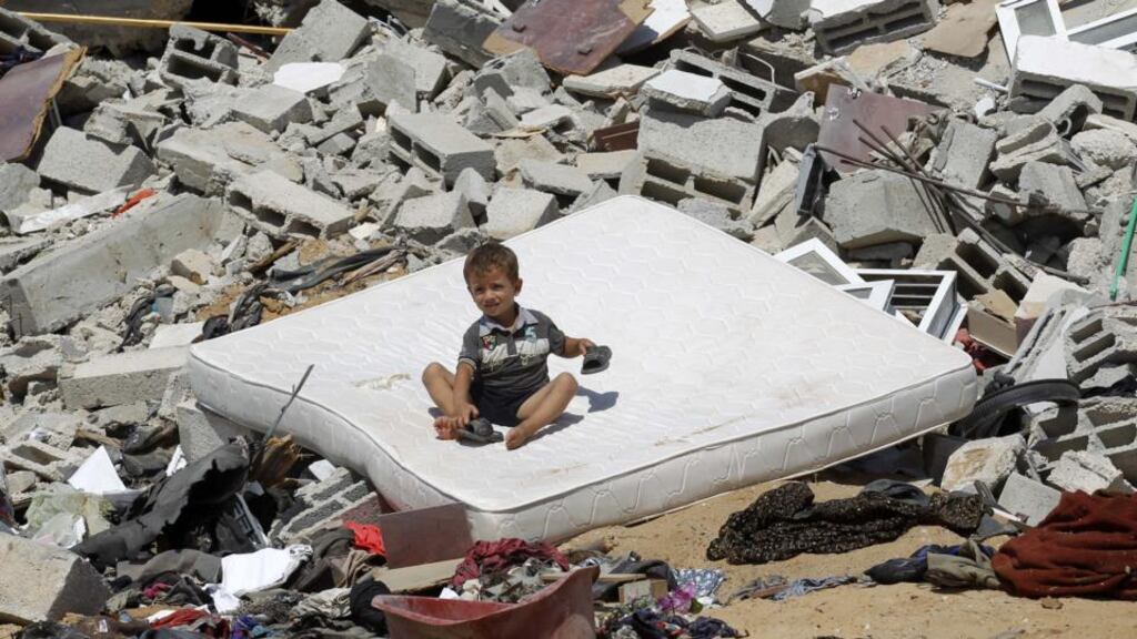 Cold comfort: a Palestinian child in the rubble of a house destroyed by an Israeli air strike. Photograph: Said Khatib/AFP/Getty