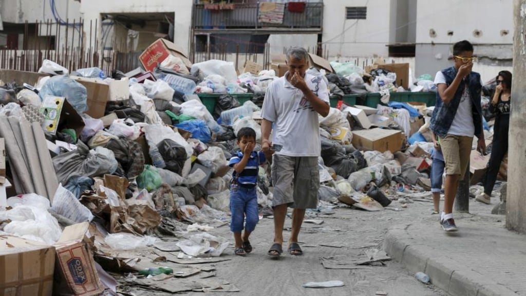 Residents cover their noses as they walk past garbage piled up along a street in Beirut, Lebanon, on Wednesday. Photograph:  Mohamed Azakir/Reuters