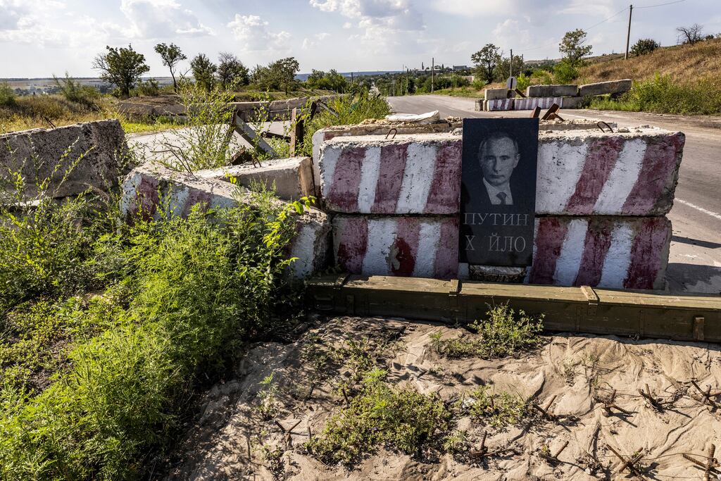 A gravestone with the carved image of Russian president Vladimir Putin leans against a highway checkpoint near Druzhkivka, Ukraine. File photograph: David Guttenfelder/The New York Times