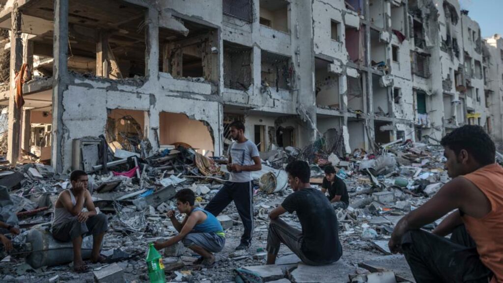 Palestinians rest outside destroyed homes in Beit Lahiya, in the northern Gaza Strip, yesterday. Photograph: Sergey Ponomarev/The New York Times