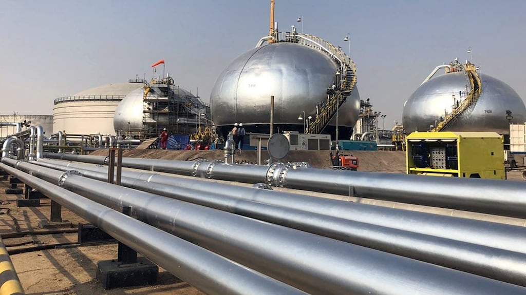 Three-phase spheroids stand behind pipelines at Saudi Aramco’s crude oil processing facility, in Abqaiq, Saudi Arabia.