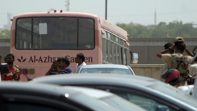 Pakistani volunteers stand beside the bus that was carrying Shia Muslims and attacked by gunmen in Karachi. At least 43 members of Pakistan’s Shia Ismaili minority were killed. Photograph: Rizwan Tabassum/AFP/Getty Images