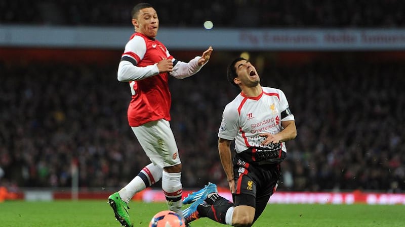 Liverpool’s Luis Suarez goes to ground after a challenge from Arsenal’s Alex Oxlade-Chamberlain at Emirates Stadium. Photograph: Adam Davy/PA Wire