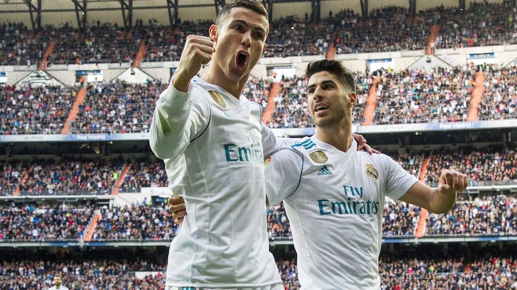 Real Madrid’s Portuguese forward Cristiano Ronaldo celebrates with his team-mate Marco Asensio after scoring against Sevilla during their Spanish Primera Division league game at Santiago Bernabeu Stadium in Madrid. Photograph: Rodrigo Jimenez/EPA