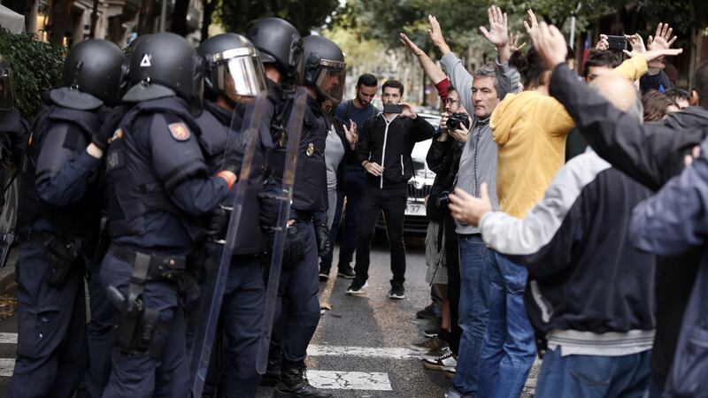 People raise their arms in front of Spanish police after the seizure of ballot boxes in a polling station in Barcelona. Photograph: Pau Barren/Getty Images