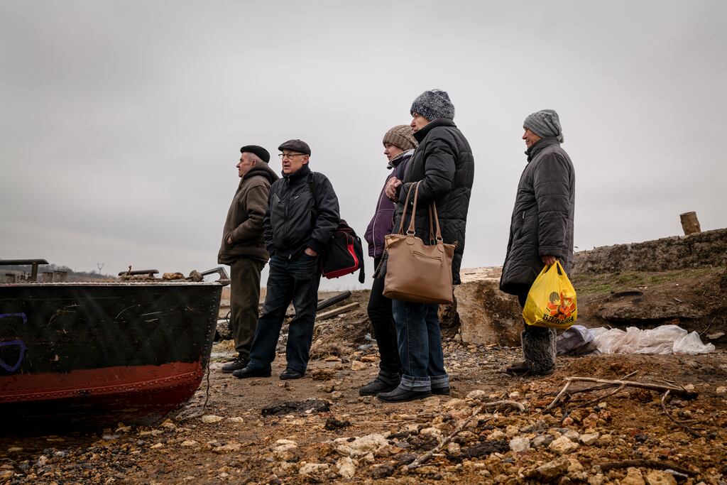 People wait for a rowboat to cross a tributary of the Dnieper River, in the Kherson region of Ukraine. Photograph: Nicole Tung/New York Times