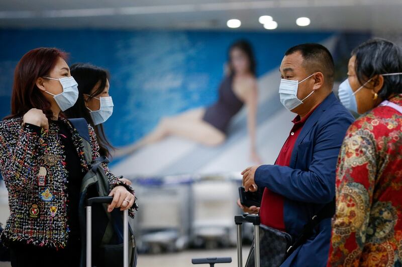 Passengers wearing face masks who arrived from Guangzhou, China gather at the Ninoy Aquino International Airport in Manila, Philippines on Wednesday. At least nine people have died and more than 400 people are confirmed infected by the coronavirus which was first detected in Wuhan, China. Photograph: Mark R Cristino/EPA.
